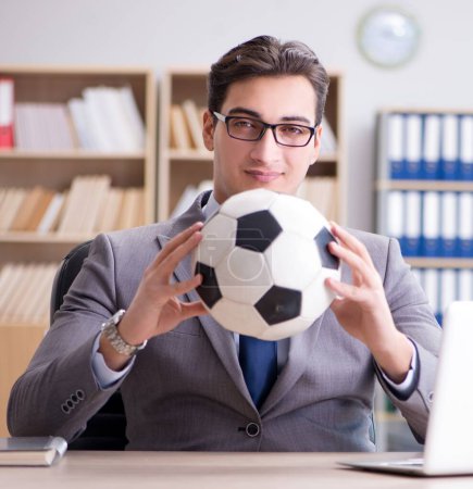 Téléchargez les photos : L'homme d'affaires avec ballon de football au bureau - en image libre de droit