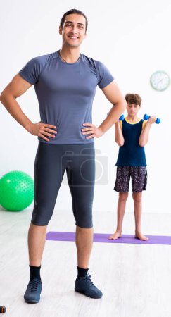Foto de El joven padre y su hijo haciendo ejercicios - Imagen libre de derechos