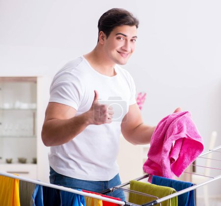 Téléchargez les photos : L'homme faisant la lessive à la maison - en image libre de droit