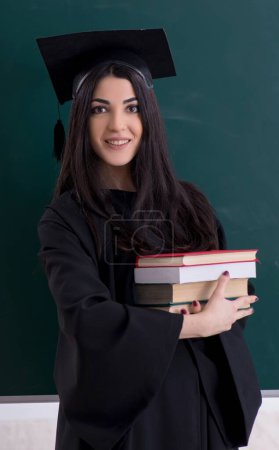 Photo for The female graduate student in front of green board - Royalty Free Image