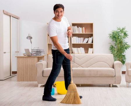 Téléchargez les photos : L'homme qui nettoie la maison avec un balai - en image libre de droit