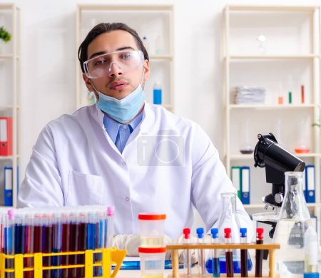 Foto de El joven químico que trabaja en el laboratorio - Imagen libre de derechos