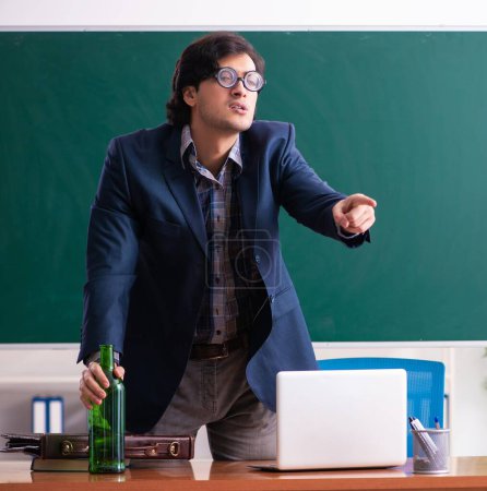 Photo for The male teacher drinking in the classroom - Royalty Free Image