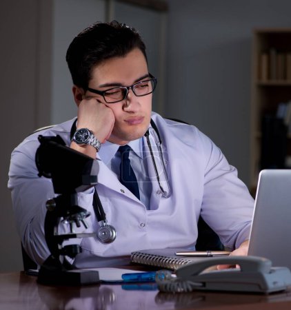 Photo for The young doctor working late in the office - Royalty Free Image