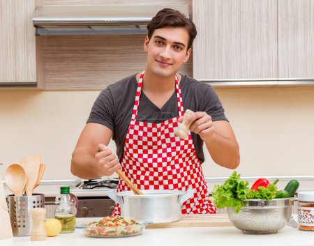 Téléchargez les photos : L'homme cuisinier homme préparant la nourriture dans la cuisine - en image libre de droit