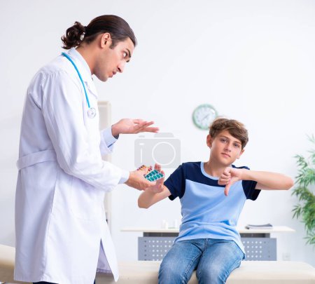Photo for The young male doctor examining boy in the clinic - Royalty Free Image
