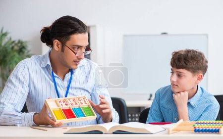 Foto de El joven padre ayudando a su hijo a prepararse para el examen - Imagen libre de derechos