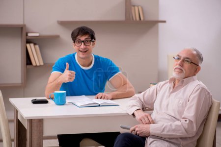 Photo for Young student and his grandfather at home - Royalty Free Image
