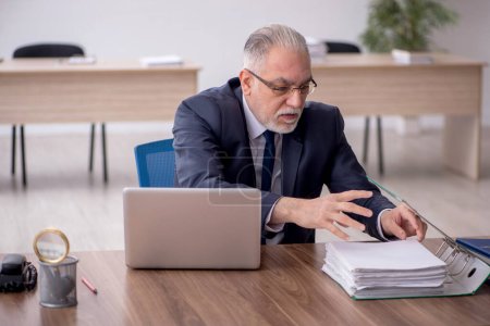 Photo for Old employee sitting at workplace - Royalty Free Image