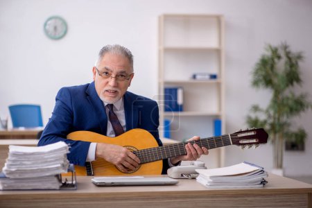 Téléchargez les photos : Old employee playing guitar in the office - en image libre de droit