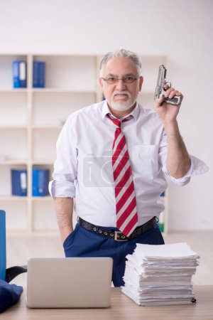 Photo for Old employee unhappy with excessive work at workplace - Royalty Free Image