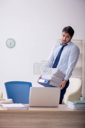Foto de Empleado joven empresario sentado en el lugar de trabajo - Imagen libre de derechos