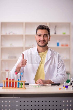 Téléchargez les photos : Young chemist sitting at the lab - en image libre de droit