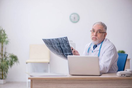 Téléchargez les photos : Vieux médecin radiologue travaillant à l'hôpital - en image libre de droit
