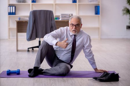 Téléchargez les photos : Ancien employé faisant des exercices sportifs pendant la pause - en image libre de droit