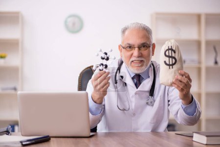 Téléchargez les photos : Vieux médecin dans le concept de rémunération - en image libre de droit