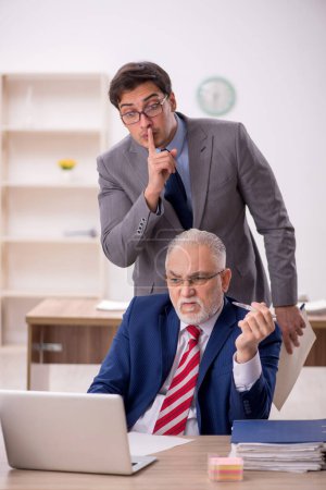 Téléchargez les photos : Deux collègues masculins assis sur le lieu de travail - en image libre de droit