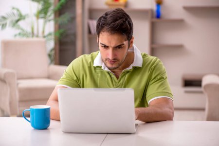 Photo for Young male freelancer working from home during pandemic - Royalty Free Image
