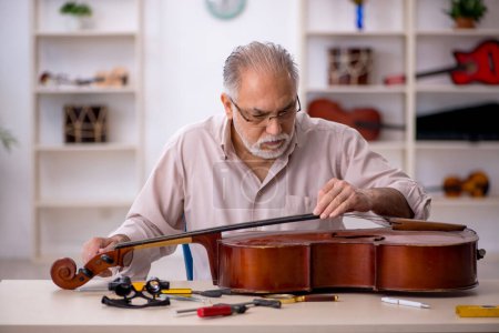 Photo for Old repairman repairing musical instruments at workshop - Royalty Free Image