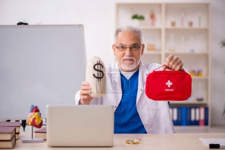 Téléchargez les photos : Vieux médecin dans le concept de rémunération - en image libre de droit