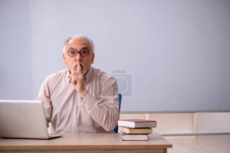 Téléchargez les photos : Vieil enseignant devant le tableau blanc - en image libre de droit