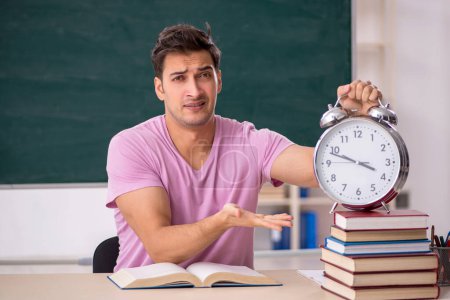 Photo for Young student preparing for exams in time management concept - Royalty Free Image