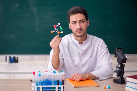 Photo for Young chemist teacher sitting in the classroom - Royalty Free Image