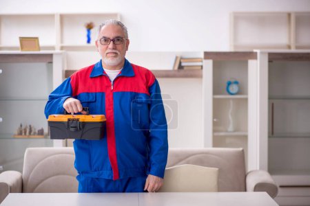 Photo for Old carpenter holding toolbox at home - Royalty Free Image