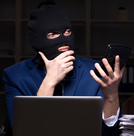 Foto de El empleado masculino robando información en la oficina por la noche - Imagen libre de derechos