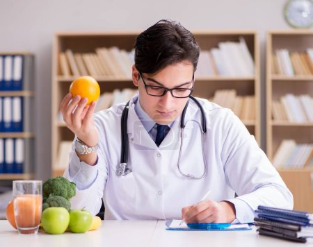 Foto de El médico en concepto de dieta con frutas y verduras - Imagen libre de derechos