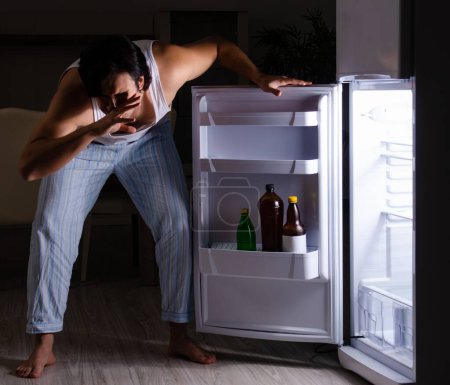 Photo for The man breaking diet at night near fridge - Royalty Free Image