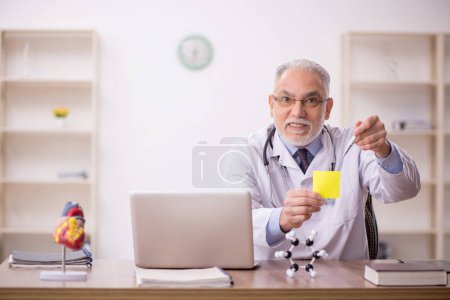 Photo for Old doctor working in the clinic - Royalty Free Image