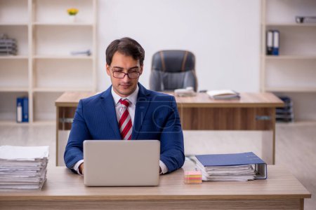 Téléchargez les photos : Jeune homme d'affaires employé et trop de travail au bureau - en image libre de droit