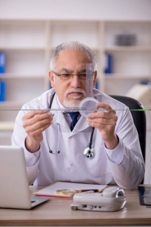 Photo for Old doctor holding goniometer at the hospital - Royalty Free Image
