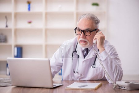 Photo for Old doctor in telemedicine concept - Royalty Free Image