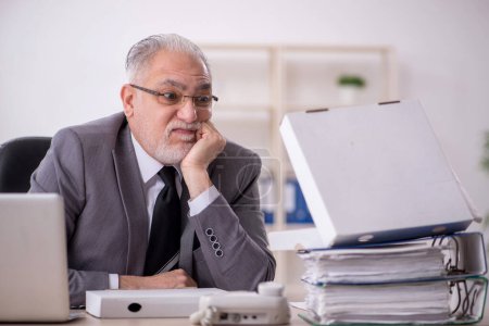 Photo for Old businessman employee eating pizza at workplace - Royalty Free Image