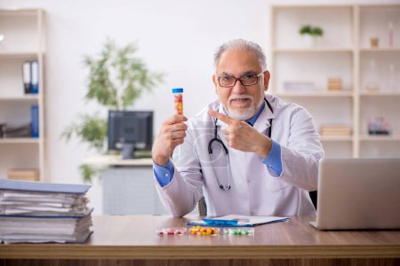 Téléchargez les photos : Vieux médecin pharmacien dans le concept de synthèse des médicaments - en image libre de droit