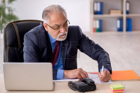 Foto de Empleado de negocios envejecido que trabaja en el lugar de trabajo - Imagen libre de derechos