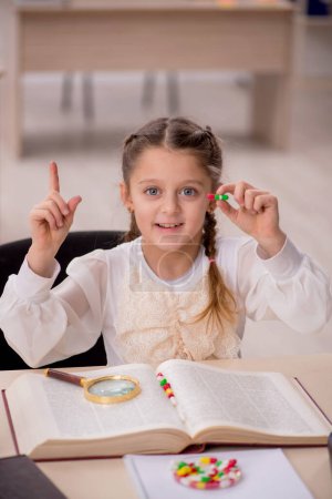 Photo for Little girl in drugs synthesis concept in the classroom - Royalty Free Image