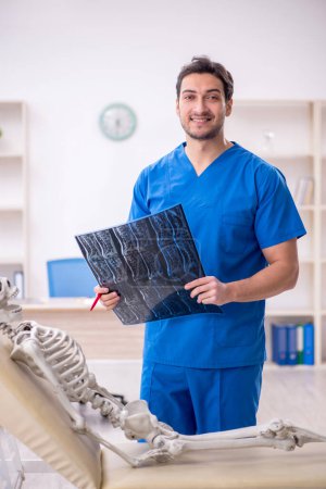 Foto de Médico radiólogo joven y paciente esqueleto en la clínica - Imagen libre de derechos