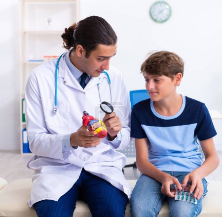 Téléchargez les photos : Le jeune homme médecin examinant garçon à la clinique - en image libre de droit