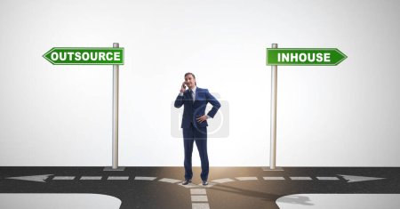 Photo for Businessman at crossroads deciding between outsourcing and inhouse - Royalty Free Image