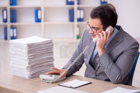 Photo for Young businessman employee unhappy with excessive work - Royalty Free Image