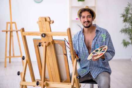 Téléchargez les photos : Jeune homme appréciant la peinture à la maison - en image libre de droit