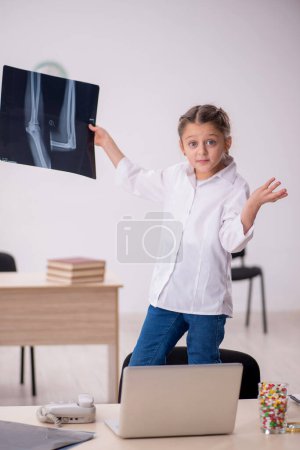 Téléchargez les photos : Little girl playing doctor radiologist at the hospital - en image libre de droit