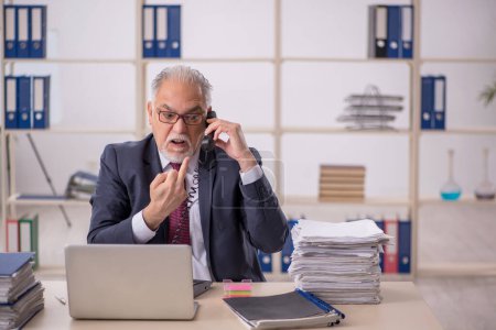 Téléchargez les photos : Homme d'affaires âgé employé travaillant sur le lieu de travail - en image libre de droit