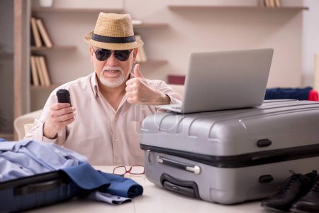 Foto de Aged man preparing for trip at home - Imagen libre de derechos