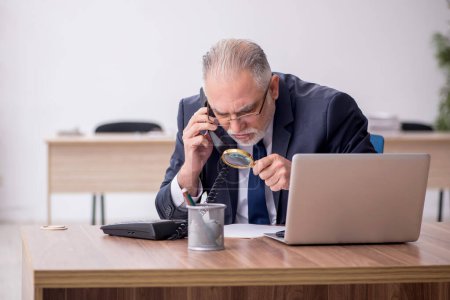 Photo for Old employee sitting at workplace - Royalty Free Image