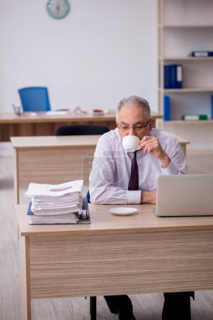 Photo for Old employee drinking coffee during break - Royalty Free Image