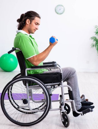 Foto de El joven en silla de ruedas haciendo ejercicios en el interior - Imagen libre de derechos